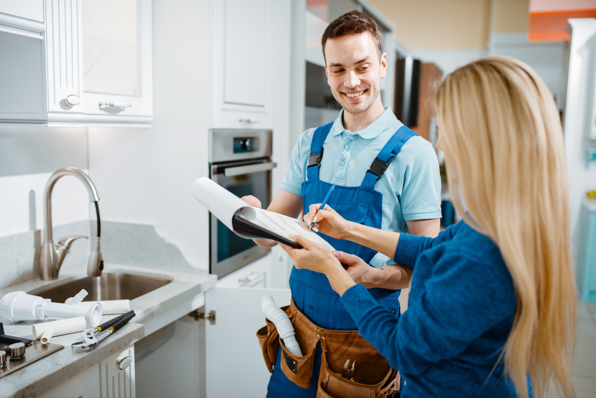 Male plumber and female customer in the kitchen